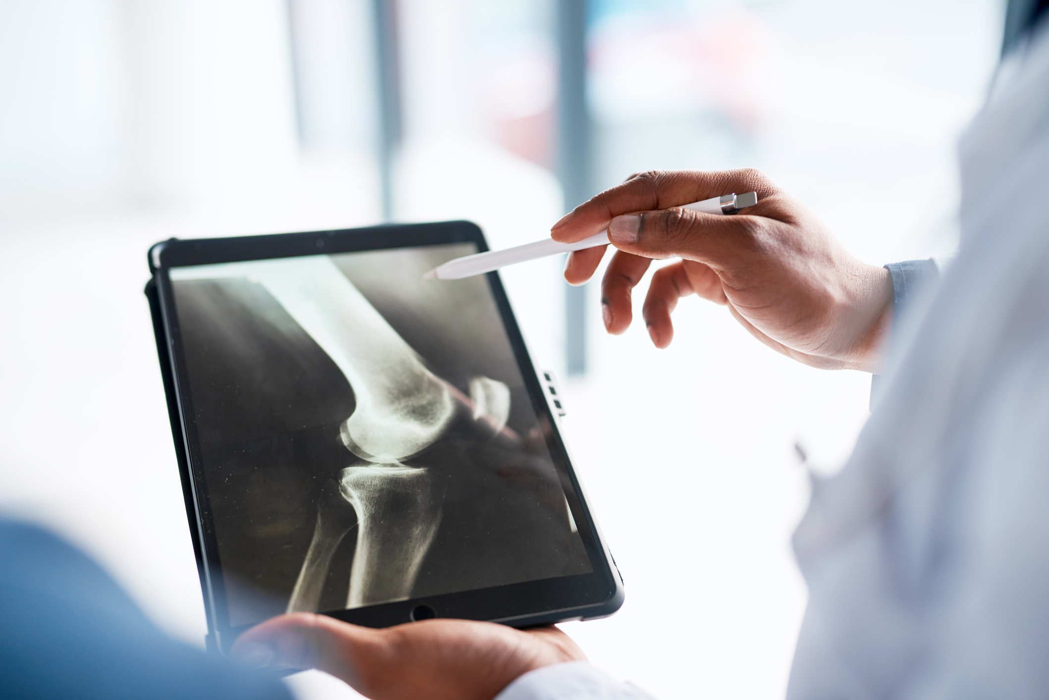 Hands, doctor and tablet with x ray in hospital for research, test results or exam in clinic. Healthcare, radiology or male medical professional with touchscreen technology for mri, mammogram or xray Hands, doctor and tablet with x ray in hospital for research, test results or exam in clinic